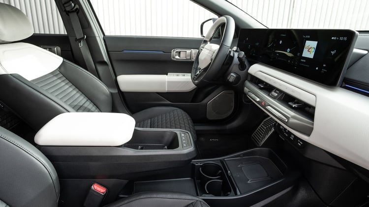 Poste de conduite de la Kia EV4 Fastback avec écran panoramique et sellerie bicolore.
