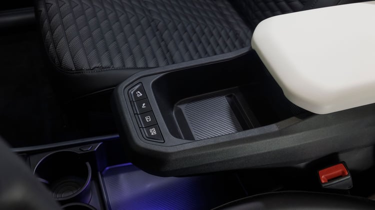 Accoudoir central avant de la Kia EV4 avec commandes intégrées et espace de rangement.