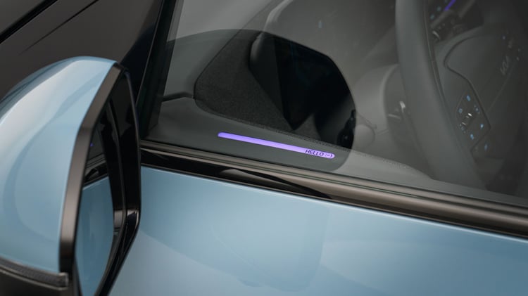 Gros plan sur la Kia EV2 : éclairage d’ambiance intérieur affichant le message « HELLO :-) » visible à travers la vitre.