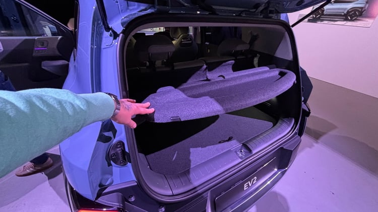 Coffre de la Kia EV2 : tablette de plage arrière amovible montrée hayon ouvert.