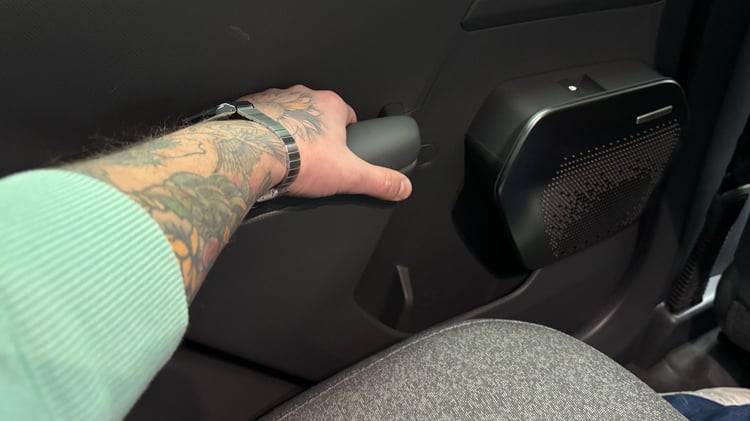Détail de la porte arrière de la Kia EV2, avec la poignée de tirage et le haut-parleur intégré.